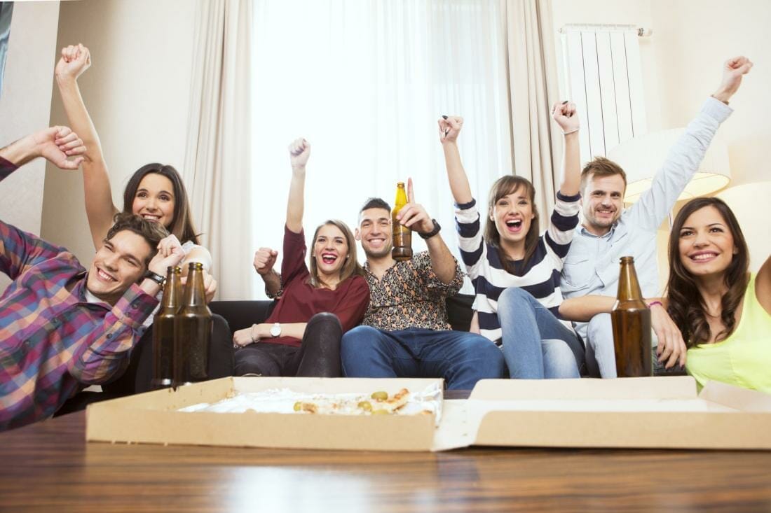 Group of friends watching TV match and cheering