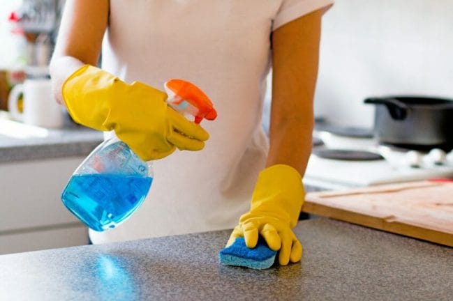 Woman Cleaning Kitchen Surfaces