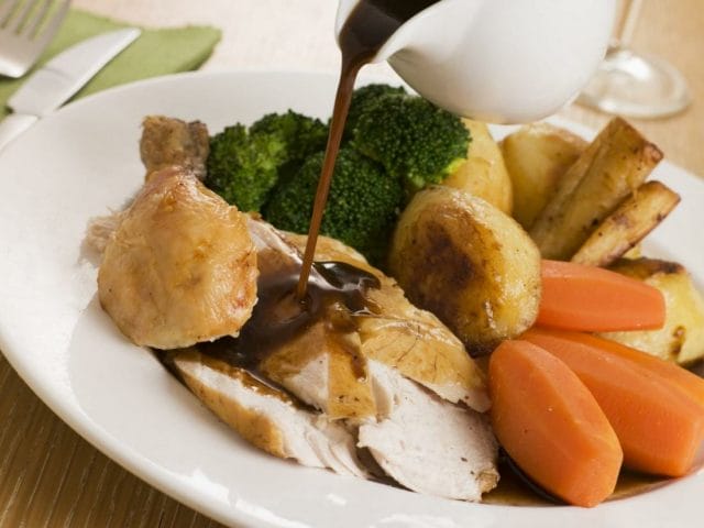 Gravy being Poured over a plate of Roast Chicken and Vegetables