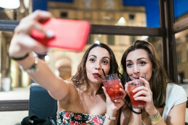 Female couple out on date for cocktails taking a selfie